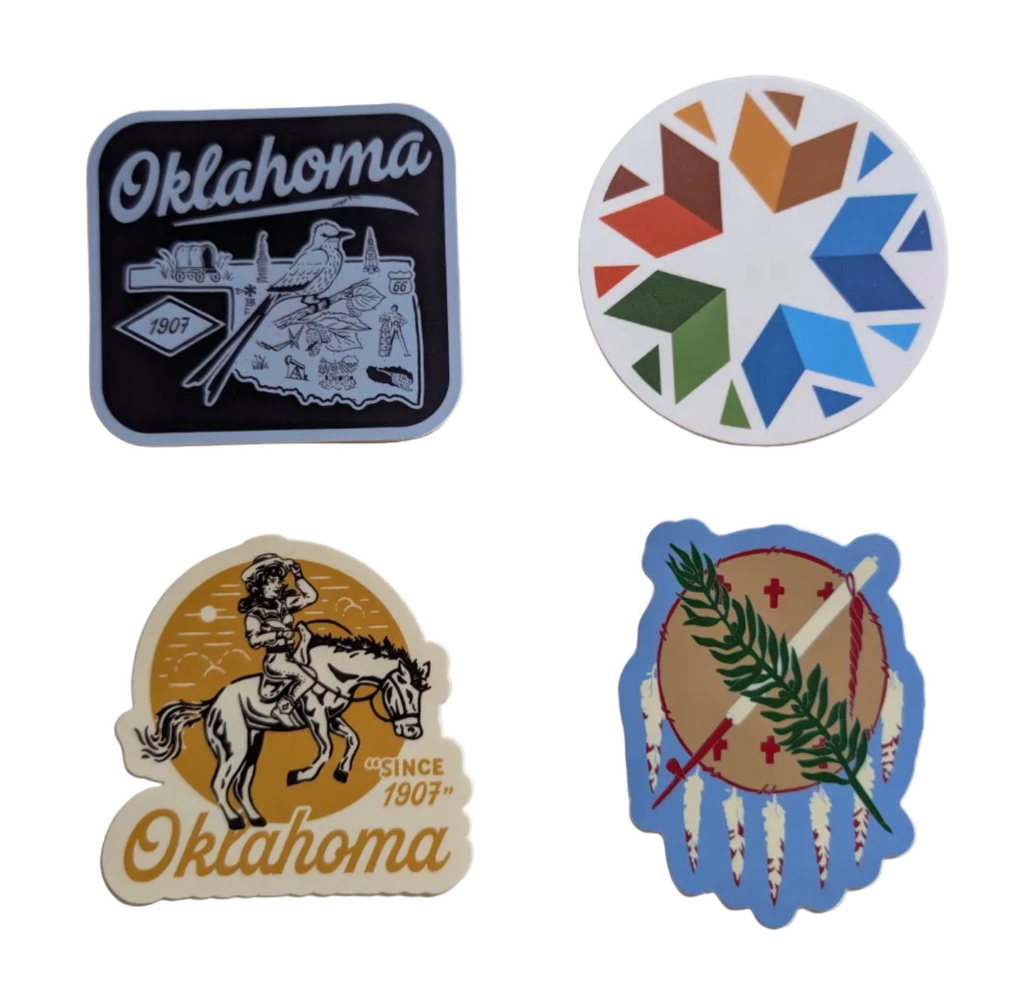 Four distinct Oklahoma-themed stickers arranged on a plain off-white surface. The set includes a black square sticker with a cowboy and rifle, a round multicolor geometric star sticker, a cream-colored oval sticker with a cowboy on a horse and 'Oklahoma Since 1907' text, and a blue-bordered circular sticker featuring the Oklahoma state flag design.